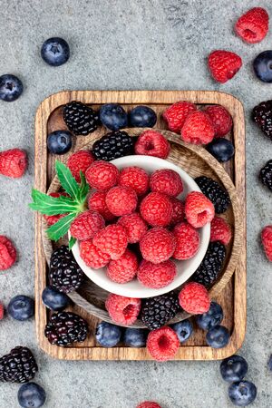 Rustic wooden plates, showing a mix of fresh berriesの写真素材