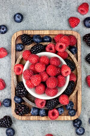Rustic wooden plates, showing a mix of fresh berriesの写真素材