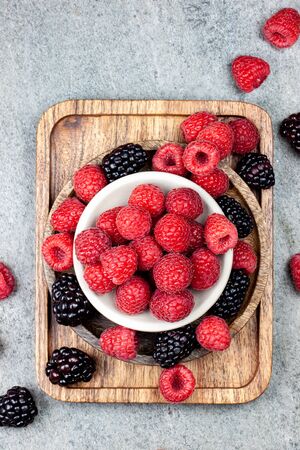 Rustic wooden plates, showing a mix of fresh berriesの写真素材
