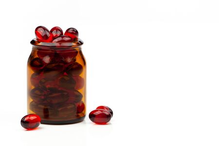 Red gel medical capsules, isolated on white background.の写真素材