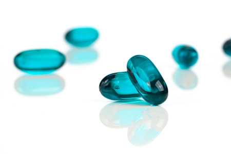 Close-up of blue medical soft gel capsules on a white background - medical supplementsの写真素材