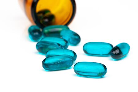 Close-up of blue medical soft gel capsules on a white background - medical supplementsの写真素材