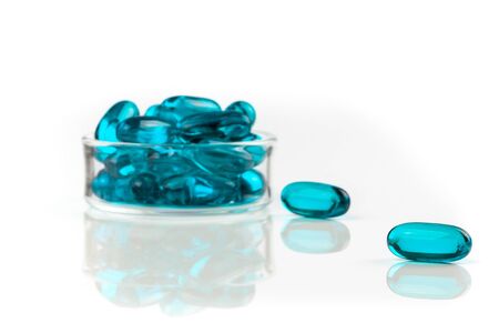 Close-up of blue medical soft gel capsules on a white background - medical supplementsの写真素材