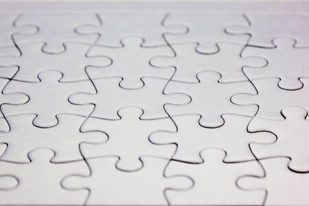 Close-up white jigsaw puzzle with all pieces connected - full frameの写真素材