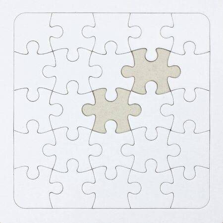 Close-up white jigsaw puzzle with a missing piece - full frame white backgroundの写真素材