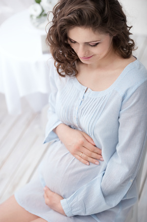 Portrait of a young pregnant woman in the interiorの写真素材