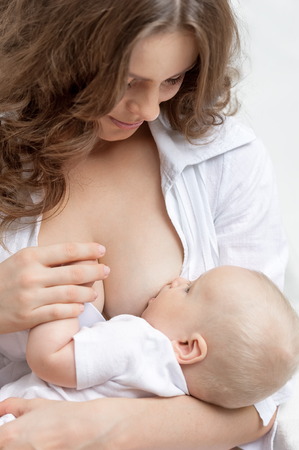 My mother is feeding her little baby breastの写真素材