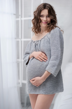 Portrait of a young pregnant woman in the interiorの写真素材