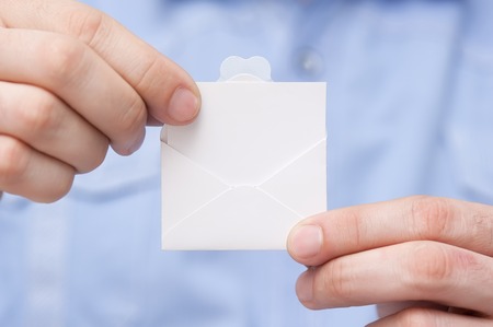 Little letter-note in the hands of menの写真素材