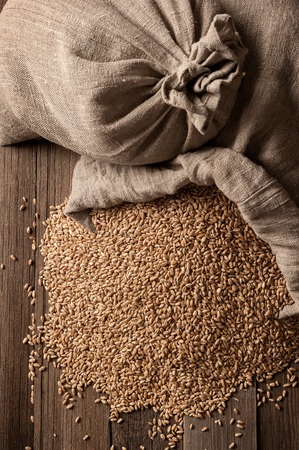Bags and scattered grain on old boardsの写真素材