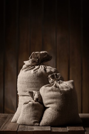 Grain of the wheat in bags on a wooden plank floorの写真素材