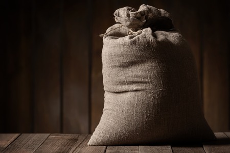 Grain of the wheat in bag on a wooden plank floorの写真素材