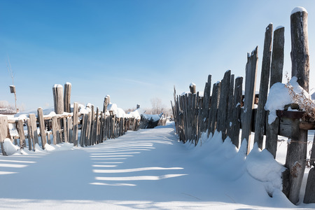 Snow-covered country road in winter sunny dayの写真素材