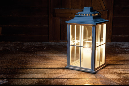 Garden lamp with lighted candles in the winter snowy nightの写真素材