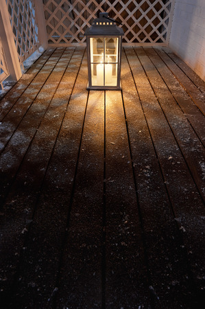 Garden lamp with lighted candles in the winter snowy nightの写真素材