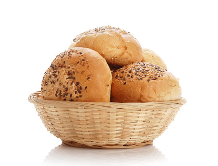Buns with sesame in a woven basket on a white backgroundの写真素材