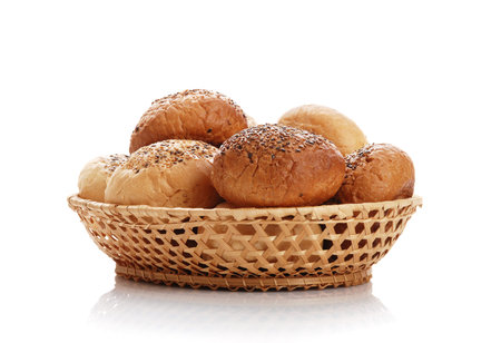 Buns with sesame in a woven basket on a white backgroundの写真素材