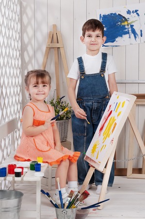 Little boy and girl painted in studioの写真素材