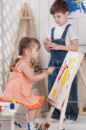 Little boy and girl painted in studioの写真素材