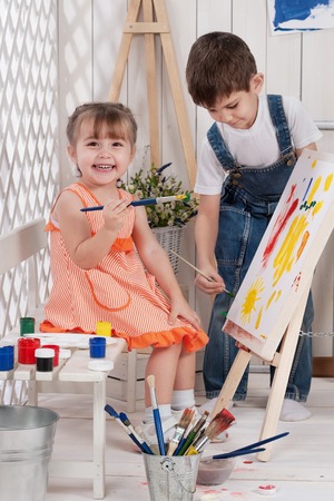 Little boy and girl painted in studioの写真素材