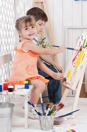 Little boy and girl painted in studioの写真素材