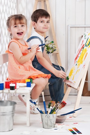 Little boy and girl painted in studioの写真素材