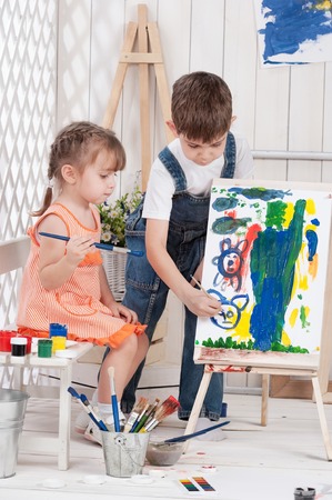 Little boy and girl painted in studioの写真素材