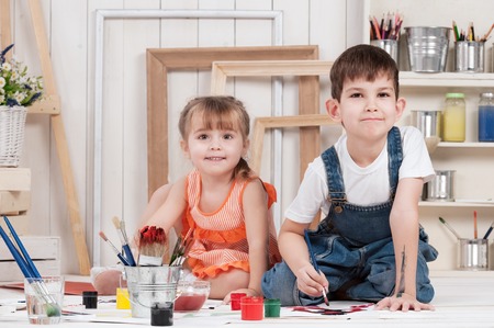 Little boy and girl painted in studioの写真素材