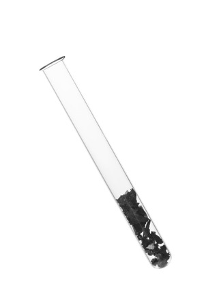 Slices of coal in a test tube on a white backgroundの写真素材