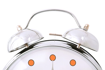 Big grey metal alarm clock. Isolated on whiteの写真素材