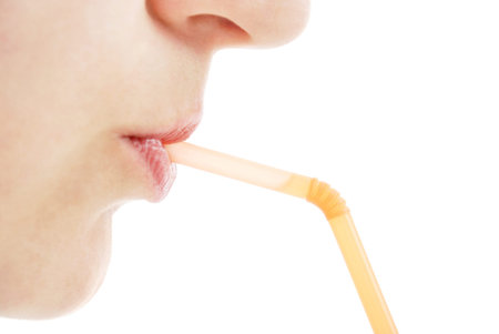 The young woman drinks juice through a tubuleの写真素材