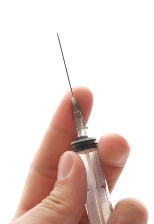 Syringe in a hand, isolated on whiteの写真素材