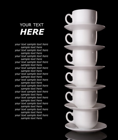 Heap of the white cups and saucers, isolated on blackの写真素材