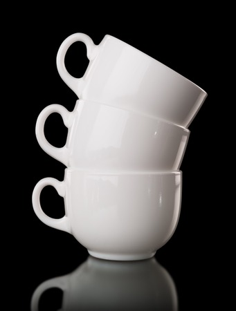 Heap of the white cups, isolated on blackの写真素材