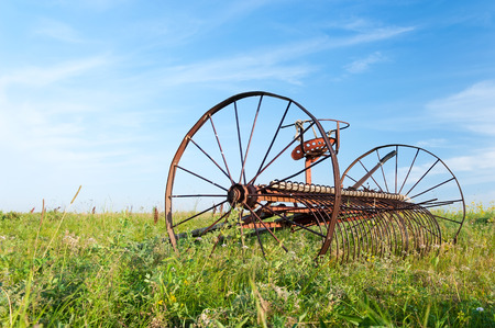 Old rusty wagon dlyauborki hay in a field on a summer dayの写真素材