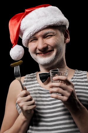 Portrait of Santa Claus with a glass of vodka and pickleの写真素材