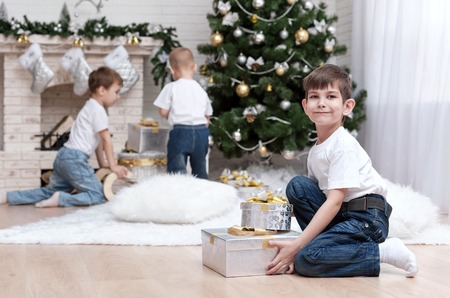 Children make out gifts at Christmas treeの写真素材