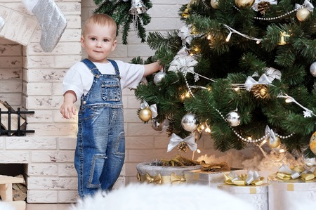 Portrait of a young boy on a sled with a gift of the Christmas treeの写真素材