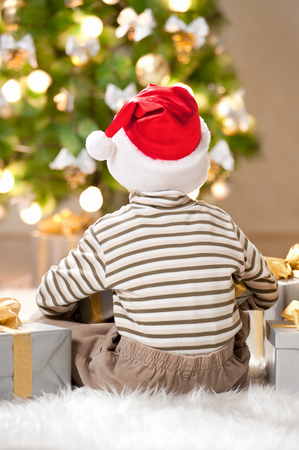 Happy little boy with a gift under the treeの写真素材