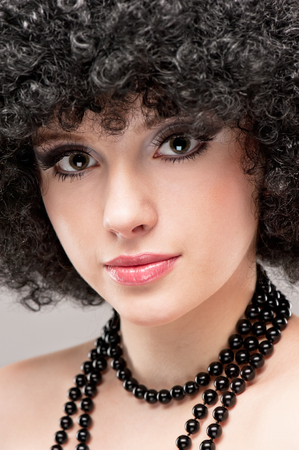 Portrait of a beautiful young brunette girl on a gray backgroundの写真素材