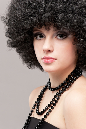 Portrait of a beautiful young brunette girl on a gray backgroundの写真素材