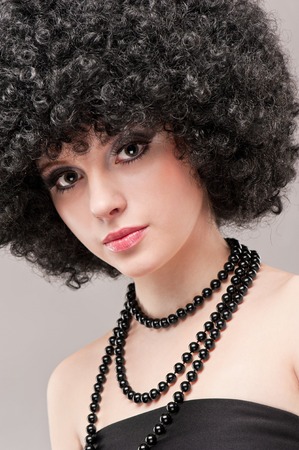 Portrait of a beautiful young brunette girl on a gray backgroundの写真素材