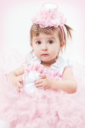 Little girl in a beautiful dress on a white backgroundの写真素材