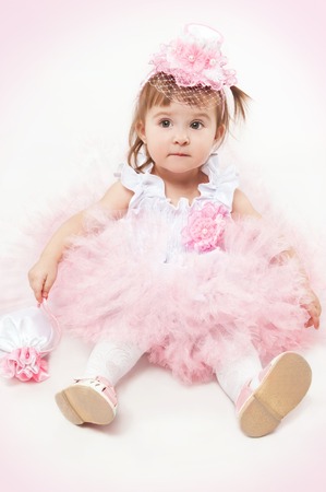Little girl in a beautiful dress on a white backgroundの写真素材