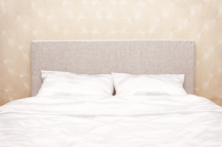 Bed with white bed-clothesの写真素材