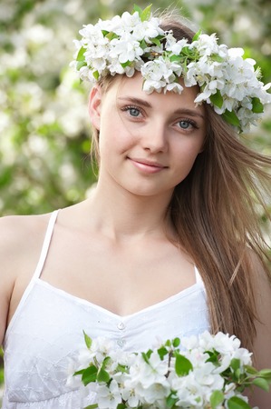 Portrait of a young girl in blossoming apple treesの写真素材