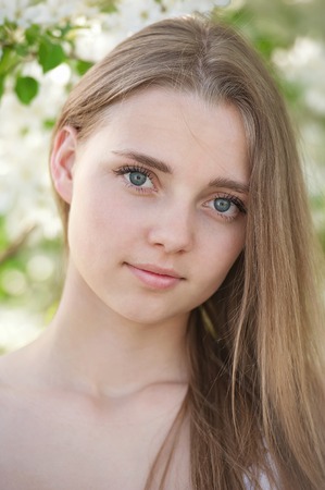 Portrait of a young girl in blossoming apple treesの写真素材