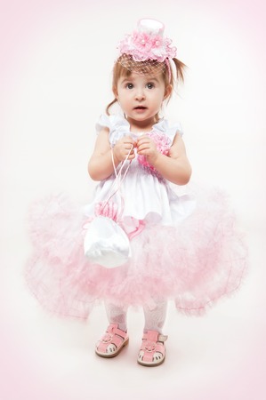 Little girl in a beautiful dress on a white backgroundの写真素材