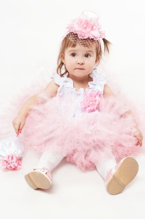 Little girl in a beautiful dress on a white backgroundの写真素材