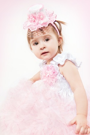 Little girl in a beautiful dress on a white backgroundの写真素材